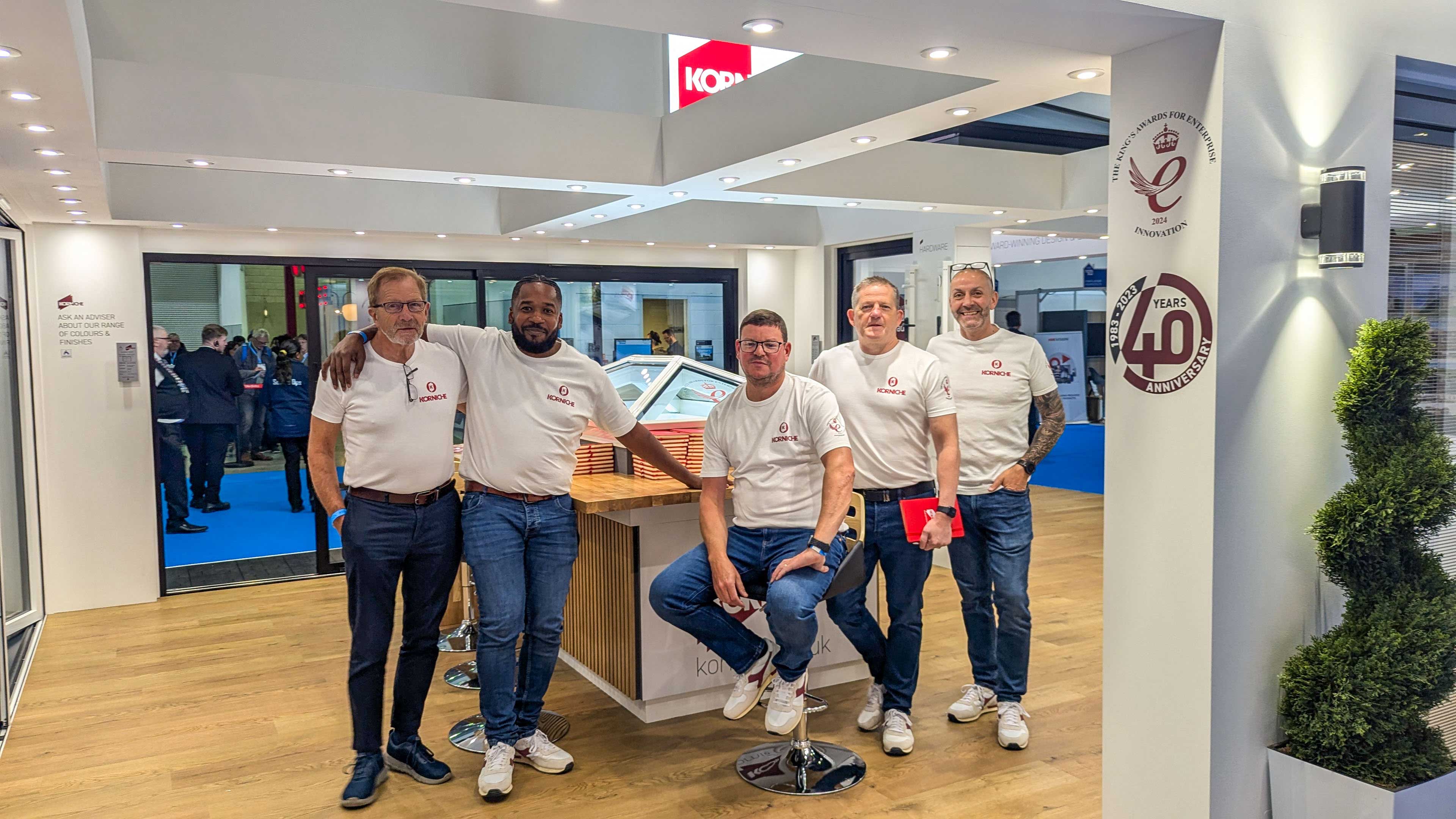 The Korniche Team: Dedicated to Excellence in Homebuilding Korniche team members posing in front of a roof lantern at the London Homebuilding & Renovating Show.