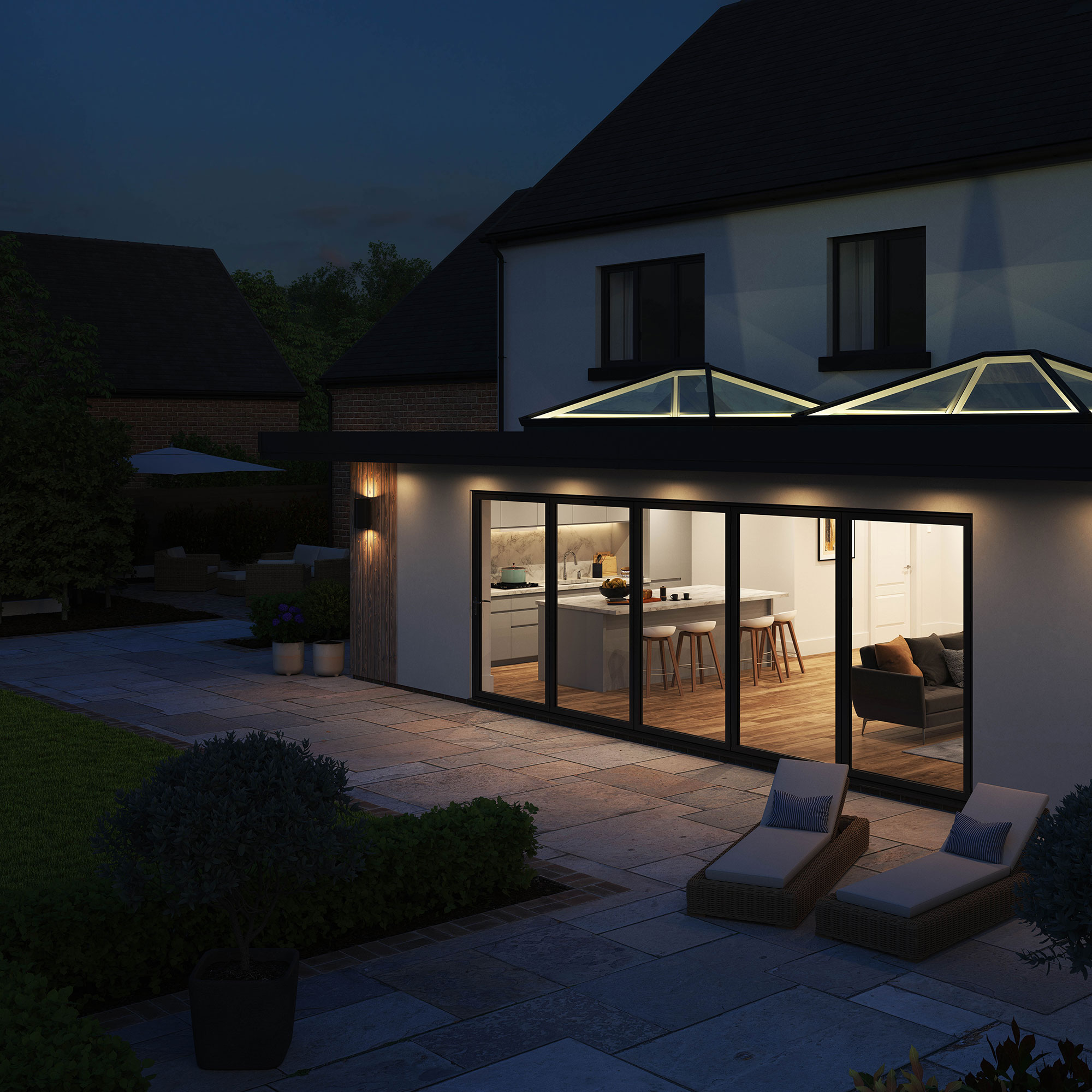 Evening Ambiance: Korniche Roof Lanterns and Korniche Bifold Doors Extension Nighttime exterior view of a home extension featuring two illuminated Korniche Roof Lanterns and Korniche bifold doors leading to a patio.