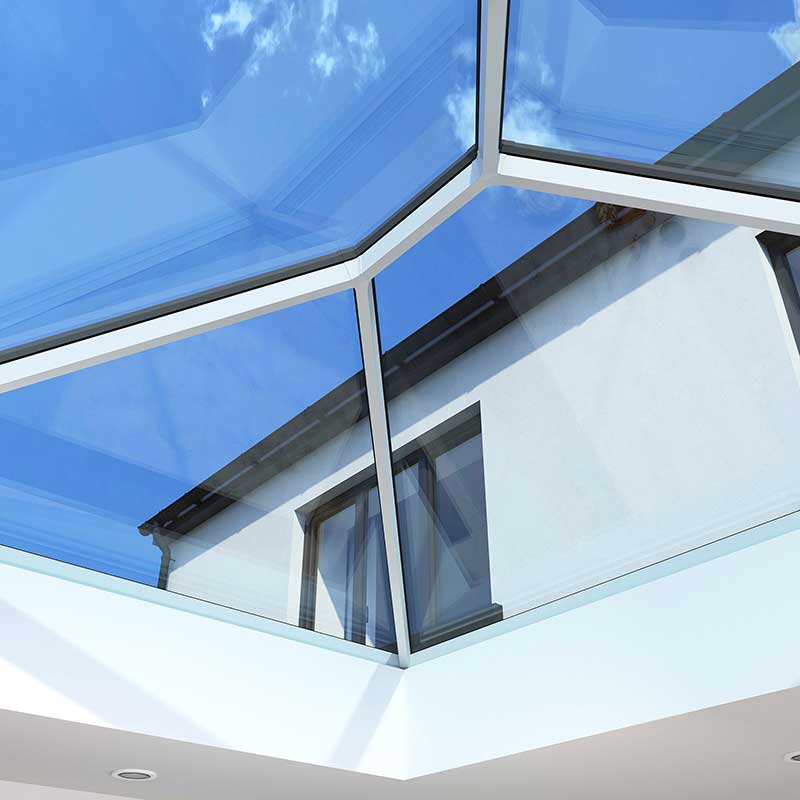 Minimalist Design, Maximum Light Korniche Roof Lantern Detail Close-up interior view of a Korniche Roof Lantern featuring a slim white internal frame and anthracite grey external frame, showcasing maximum daylight and blue sky.