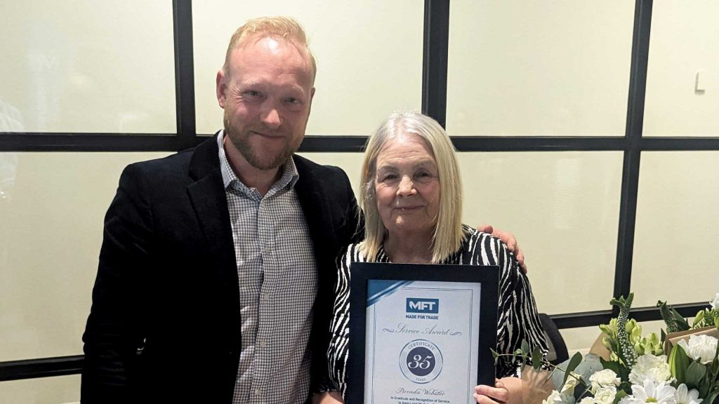 Bradley Gaunt presents Brenda Webster with a 35-year service certificate and flowers at Made For Trade.