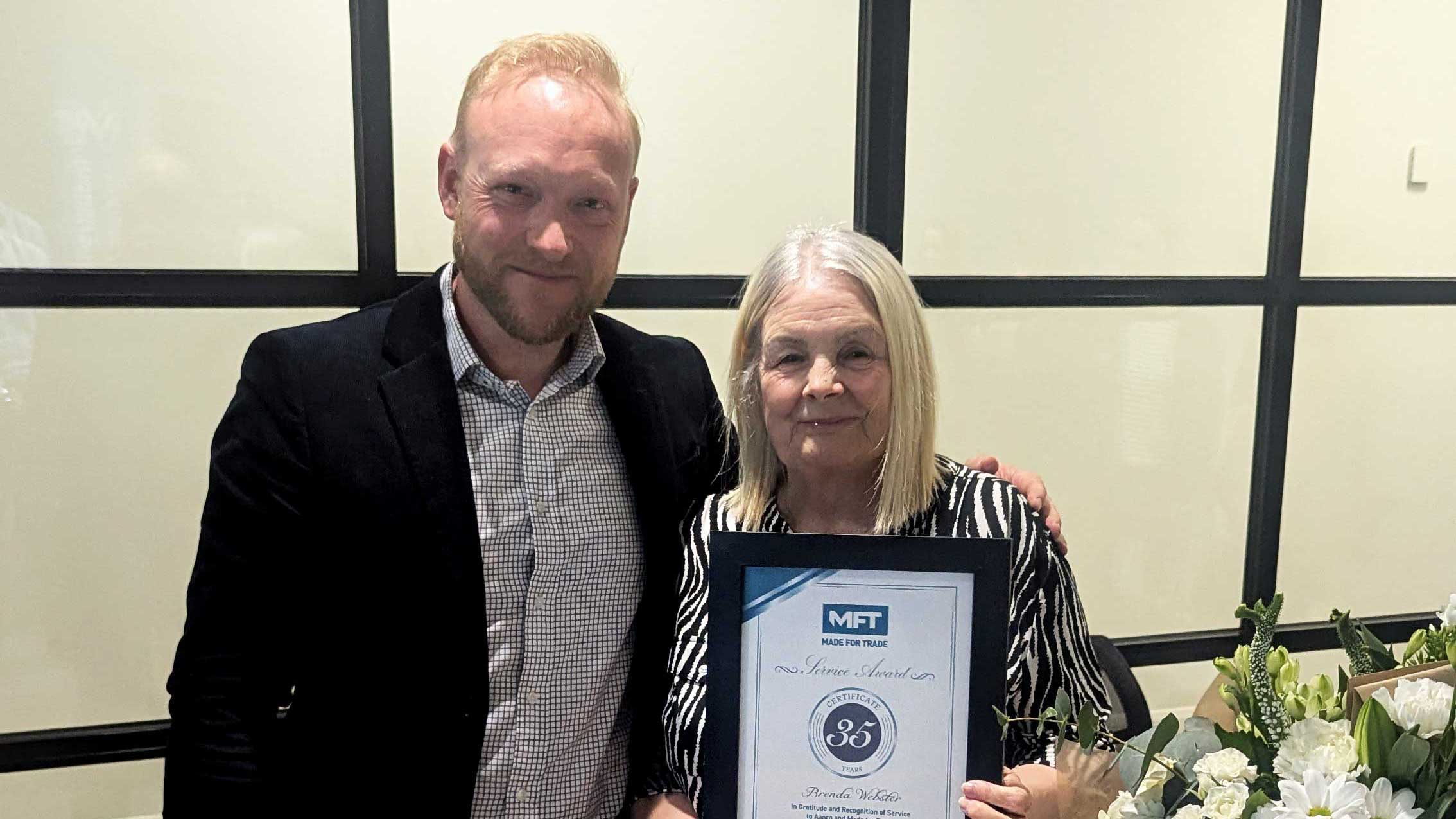 Bradley Gaunt presents Brenda Webster with a 35-year service certificate and flowers at Made For Trade.