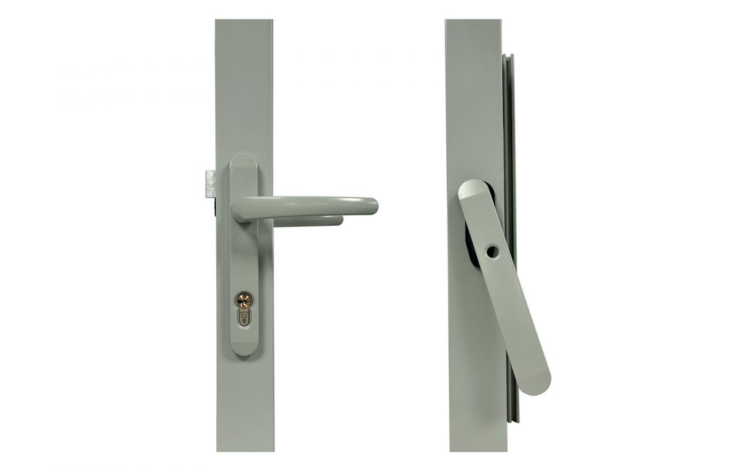 Grey bi-fold door handles: Close-up showing a shootbolt handle with a keyhole and a traffic handle, both in matching Agate Grey finish on a door frame.