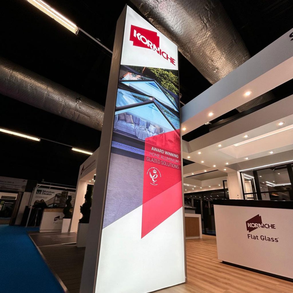 The large, distinctive Korniche brand sign next to the exhibition stand at the Harrogate Homebuilding & Renovating Show.