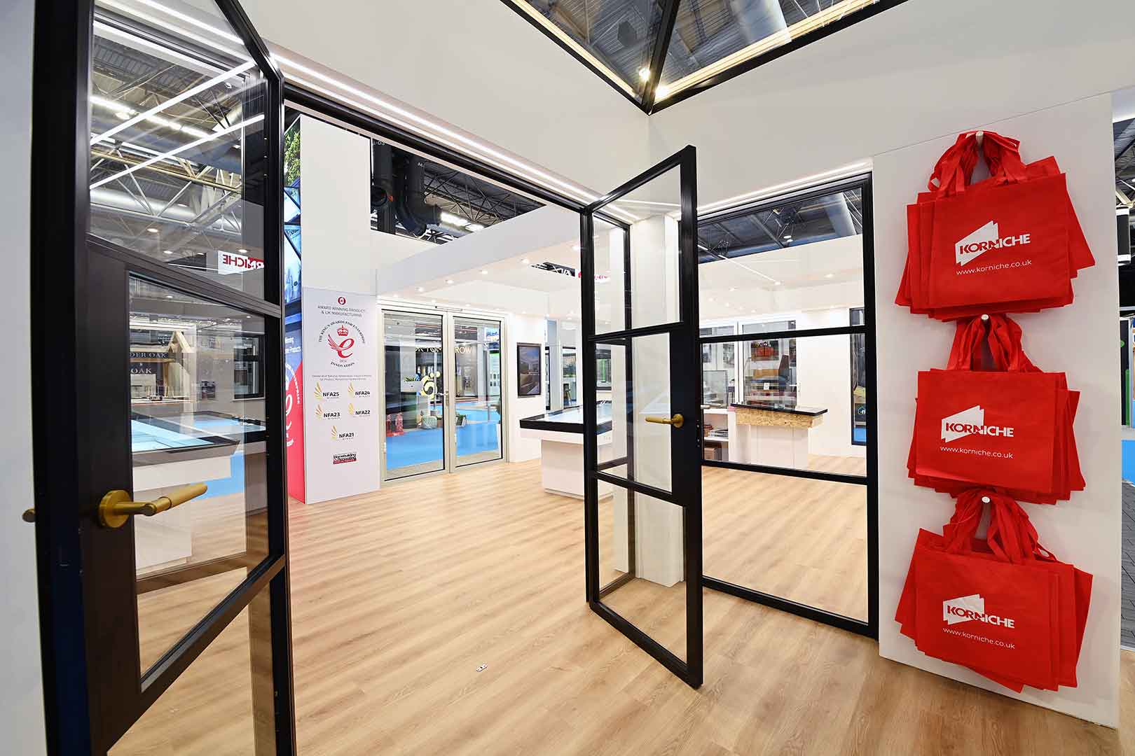 Korniche stand at Homebuilding and Renovating Show featuring internal glass partitions and aluminium glazing systems