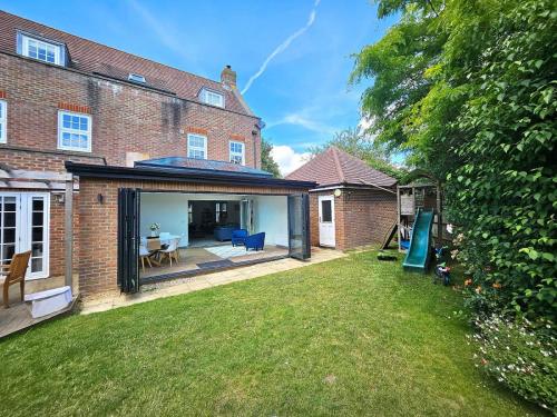 Exterior of a brick orangery extension with Korniche Roof Lantern and Bifold Doors.