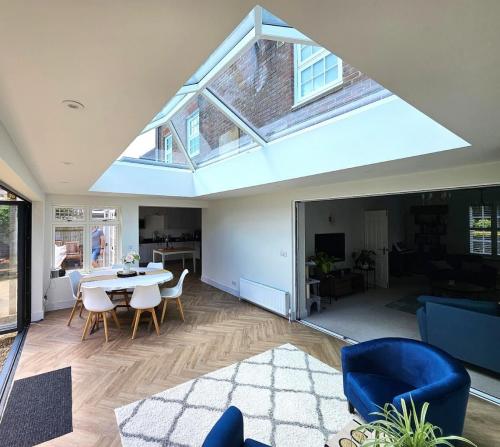 Bright orangery interior with Korniche Roof Lantern and open bifold doors.
