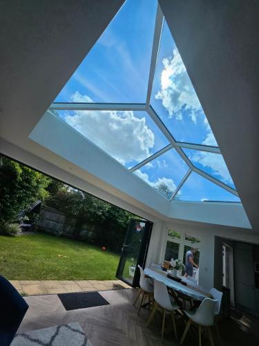 Korniche Bifold Doors open to a garden from a bright orangery with a roof lantern.